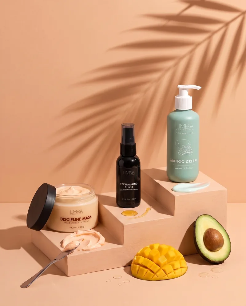 Limba anti-frizz routine: Discipline Mask, Recharging Elixir hair oil and Mango Cream on peach steps with mango and avocado